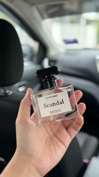 Scandal perfume bottle held in hand in car interior, camera slowly moves closer to the bottle then smoothly moves back to original position, creating a cinematic zoom effect.mp4