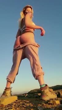 Cute_masked_blonde_kneeling_pee_outside_in_open_nature_-_ThisVid.com.mp4